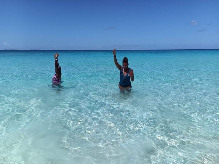 Two travelers waving in the ocean