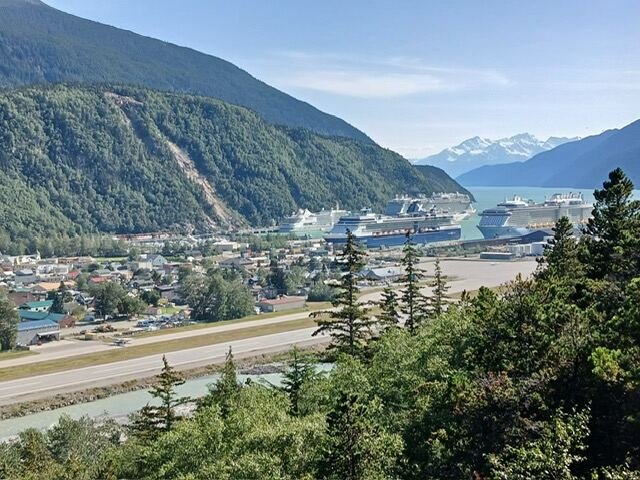 Overlook of Skagway, Alaska with cruise ships docked below the mountains