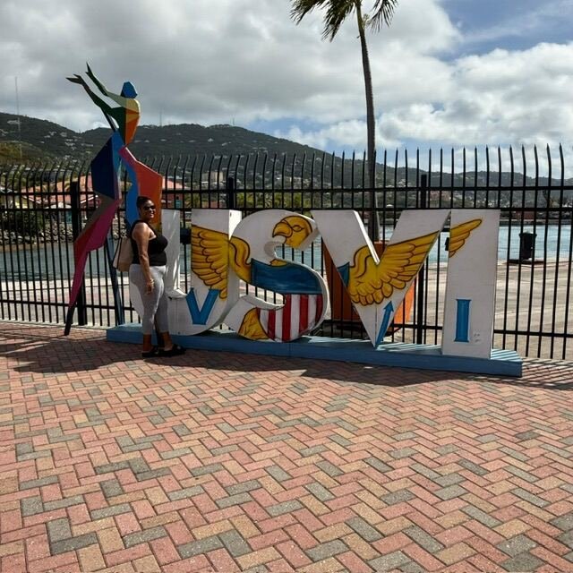 Traveler posing by the USVI sign